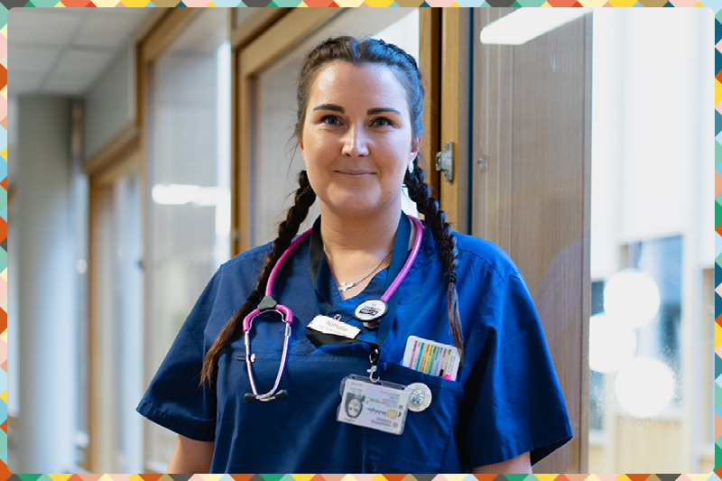Bild på en sjuksköterska i blå arbetskläder och ett rosa stetoskop