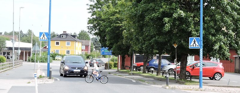 Cyklist som cyklar på cykelpassage med stillastående bil
